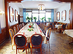 Lange Festtafel im Restaurant mit rot gepolsterten Stühlen